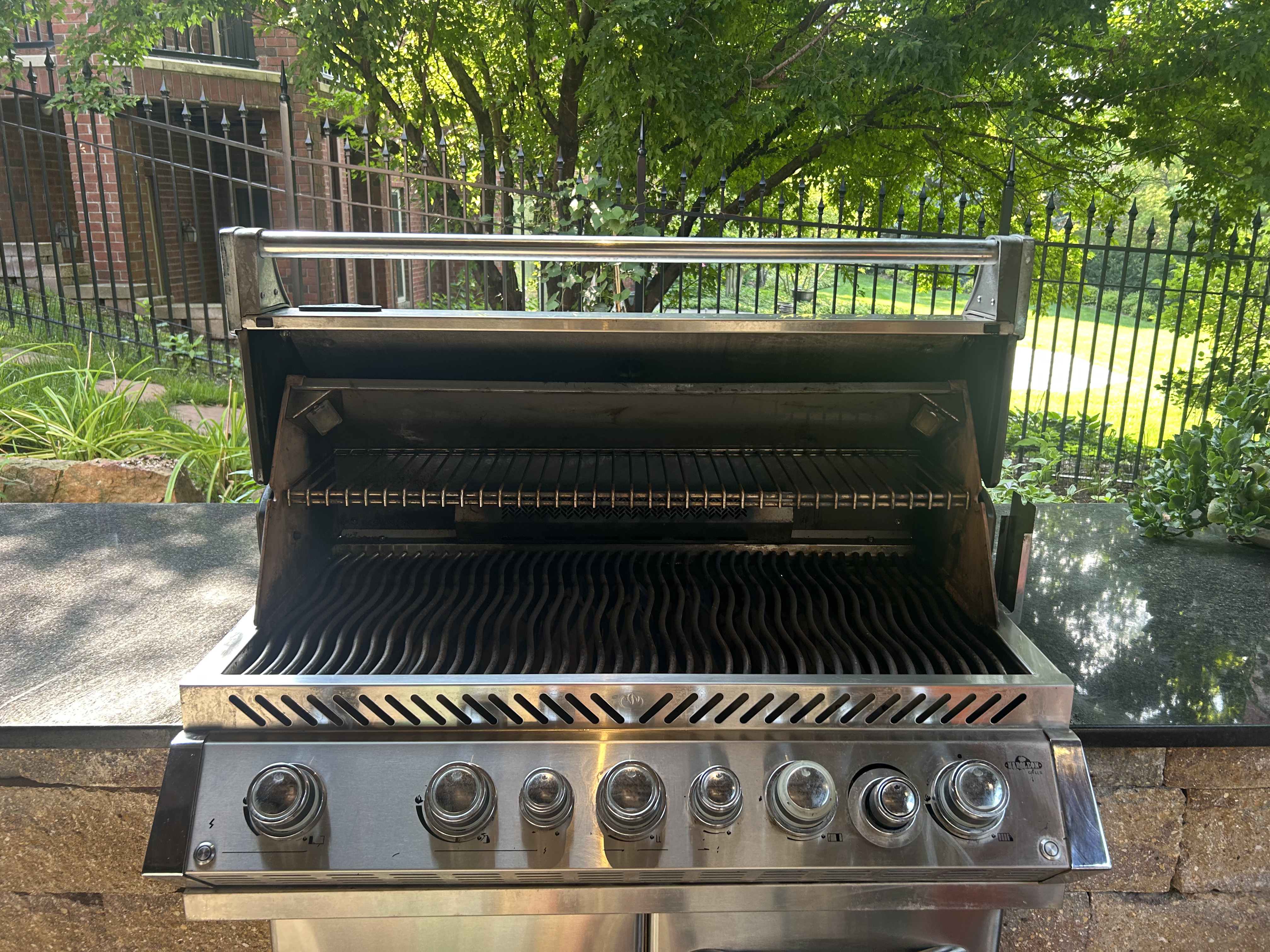 Built-in outdoor grill with wave cooking grates and open hood